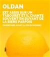 Oldan est assis sur un tabouret et il chante souvent en buvant de la bière parfois - Comédie Dalayrac